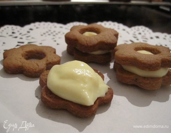 На одну половину остывшего печенья нанести крем и накрыть второй половинкой. 