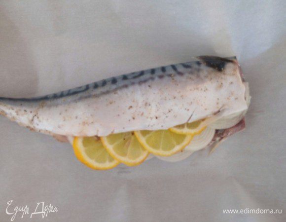 Из оставшейся половины лимона выжимаем сок и сбрызгиваем им рыбу, солим, перчим и помещаем в брюшко лук и лимон.
Теперь кладем подготовленную рыбку на противень, выстланный пергаментной бумагой, смазываем сметаной и заворачиваем, как конфету и ставим в разогретую до 180°C духовку на 30-35 минут. За 5 минут до готовности бумагу развернуть и переключить духовку в режим гриля, чтобы рыбка подрумянилась немного.