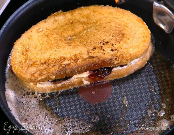 Разогреть в сковороде сливочное масло и обжаривать хлеб с сыром и вареньем с двух сторон до появления золотистой корочки.