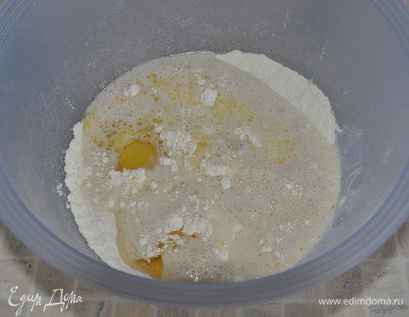 В большую миску просеять чуть больше половины муки, добавить соль, остывшее сливочное масло, яйца и разведенные в молоке дрожжи. 