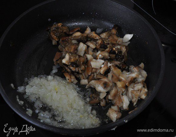 На растительном масле обжарить мелко порезанную луковицу, добавить грибы, готовить, пока не выпарится влага от грибов.
