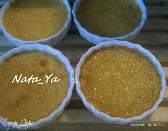 Теперь необходимо избавиться от пузырьков на поверхности крема. Я это сделала с помощью газовой горелки (этот неожиданный ход был подсказан Марком, действительно, очень эффективно), но можно и ложкой разгладить. В противень налить кипяток, так, чтобы он доходил примерно до половины высоты форм. Поместить противень в прогретую духовку и запекать крем-брюле 35-40 минут. Готовность можно проверить путём встряхивания форм, готовый крем должен колыхаться как желе.