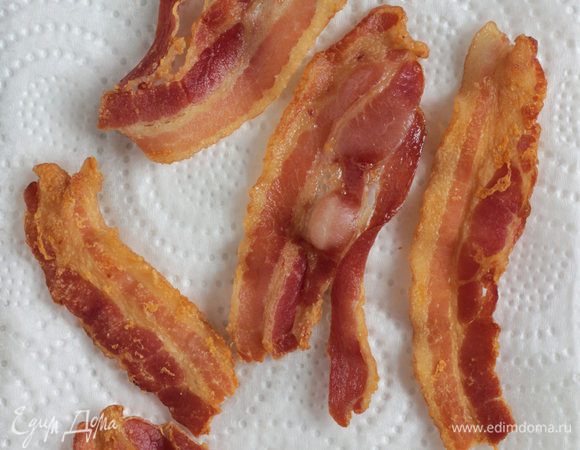 Обжарить бекон на сухой антипригарной сковороде с двух сторон, до хрустящей корочки. Готовые ломтики достаньте из сковороды и выложите на бумажное полотенце, чтобы стек лишний жир.