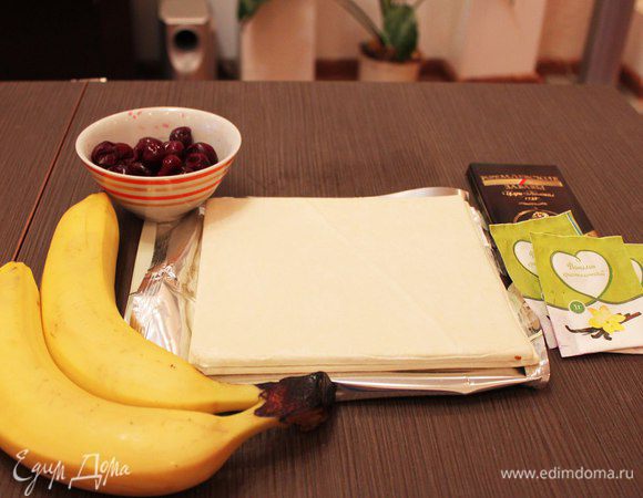 Я обычно использую уже готовое слоеное тесто, выпечка получается очень вкусная и весь процесс приготовления занимает всего 30-40 минут! 
Для начала достаем тесто из морозилки, разморозка займет 10-15 минут, а пока можно подготовить остальные ингредиенты. Вишню также заранее размораживаем и сливаем сок. 