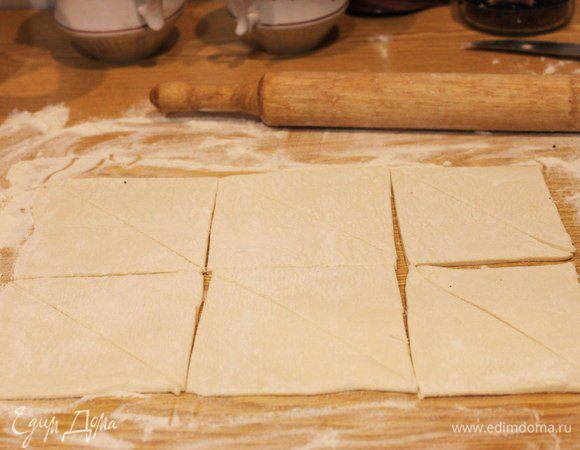 Тесто аккуратно раскатываем в одном направлении. Стол необходимо присыпать мукой, чтобы тесто не прилипало. Режем на 6 квадратов, а затем эти квадраты еще раз по диагонали, чтобы получились треугольники (1 пласта теста у меня хватает на 12 небольших круассанчиков). 