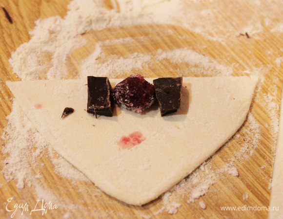 На основание полученных треугольников выкладываем начинку и заворачиваем. Каждую вишенку окунаем в сахар, можно добавить ванилин. Придаем полученным круассанчикам форму полумесяца, выкладываем на смазанный маслом противень. Я сделала несколько штучек с бананами и шоколадом, получается очень вкусно!