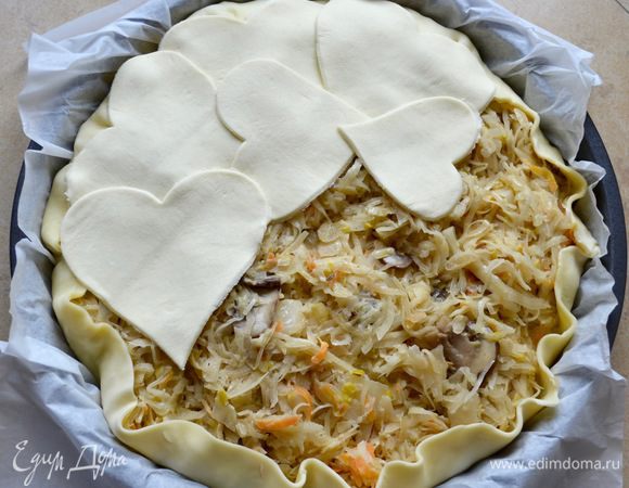 Из другого пласта теста вырезать фигурными формочками "сердечки" ("кружочки", "листики"...) и выложить их поверх начинки...