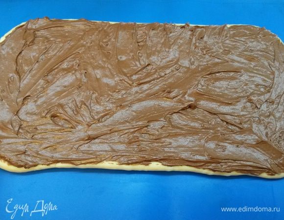 Достаем тесто из холодильника. Раскатываем тесто в прямоугольник со сторонами 30х14 см. Распределяем по тесту начинку.