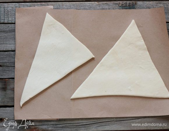Тесто раскатайте на присыпанной мукой поверхности в прямоугольник толщиной 3 мм., затем разрезать на 2 треугольники (у меня получилось 2 крупных и 2 средних треугольника).