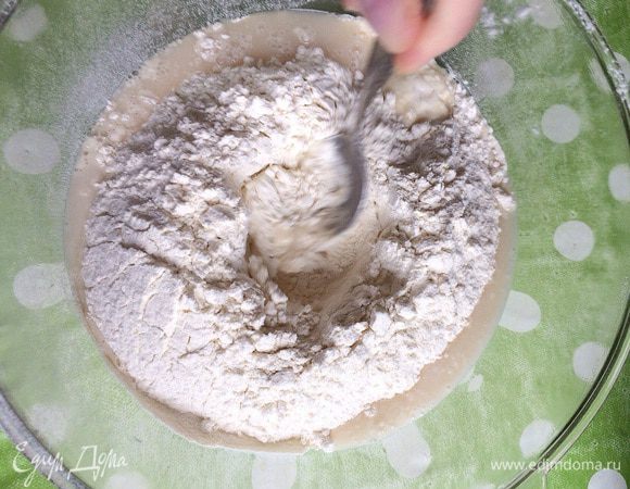 Аккуратно, понемногу, вливаем в ямку наши разведенные дрожжи с сахаром и солью. Перемешиваем смесь ложкой или вилкой, стараясь не задевать его стенки.