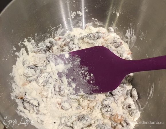 Теперь ещё один момент: соединяем просеянную муку с разрыхлителем с фруктами и хорошо перемешиваем — это позволит фруктам максимально равномерно распределиться в кексе.