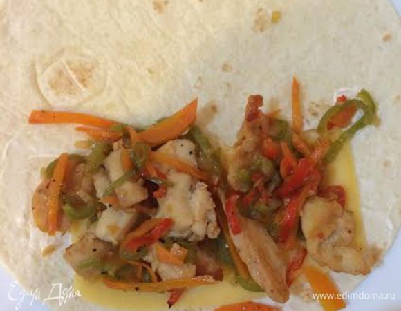 На половину тортильи выложить тонкий кусочек сыра, начинку, закрыть аккуратно второй стороной и слегка обжарить на сковороде-гриль.