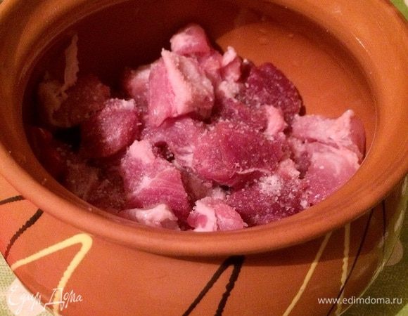 Нарезаем мясо на маленькие кусочки. Укладываем в горшочек и солим (щепотка).