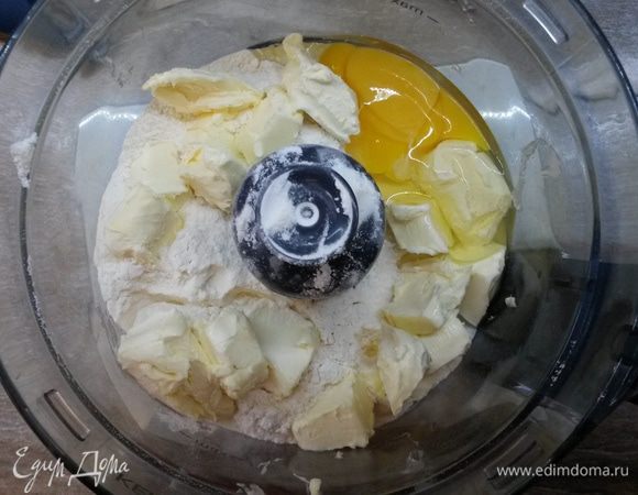 Готовим тесто бризе. Сливочное масло заранее достаем из холодильника, минут за 20. Оно должно немного размягчиться, но еще быть холодным. В кухонный комбайн выкладываем муку, соль и сахар. Сверху нарезаем кубиками масло, добавляем яйцо. В импульсном режиме делаем пару рывков до получения мучной крошки.
Высыпаем крошку на стол, добавляем ложку холодного молока, собираем тесто в шар. Растираем тесто основанием ладони движением от себя 4-5 раз. Тесто должно стать однородным. Выкладываем тесто в пищевую пленку. Убираем в холодильник на полчаса. 