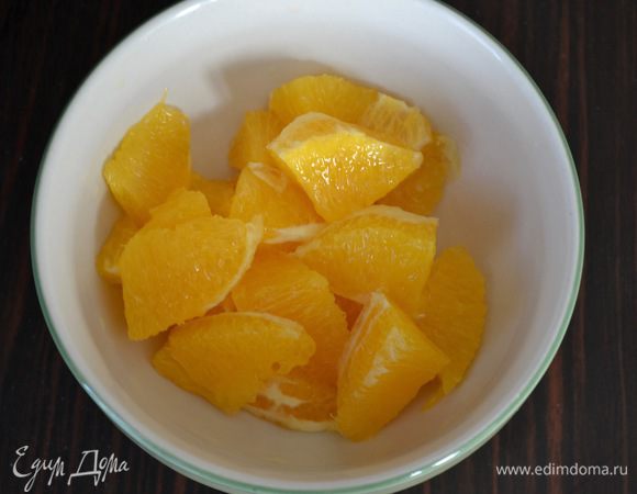 Вырезать ножом дольки апельсина, прорезая острым ножом на границе между пленкой и мякотью фрукта. Получатся вот такие дольки без пленочек. Разрезать пополам каждую дольку.