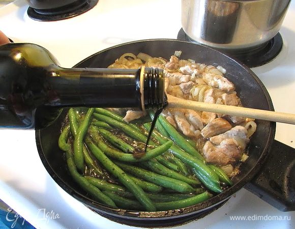 Заливаем бальзамическим уксусом и накрываем крышкой, на среднем огне, периодически помешивая, доводим до готовности — пока весь уксус не испарится и останется только мясо, лук, фасоль и масло.