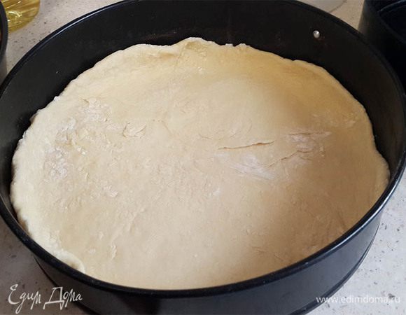 Отложить треть теста для верха. Остальное раскатать и выложить в разъемную форму, покрытую пергаментом. Сделать бортики.