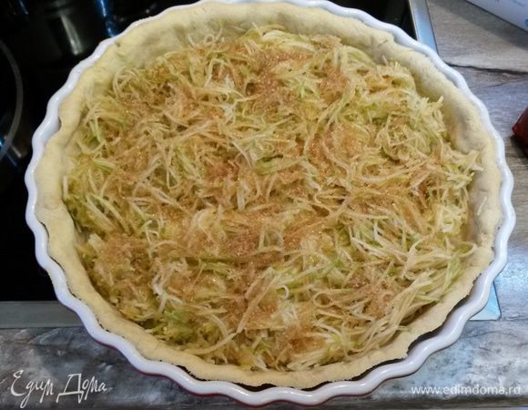 Натираем на крупной терке яблоки. Заранее это делать не нужно, иначе яблоки потемнеют и пустят сок. Я это делаю в последние 5 минут выпечки тарта без бобов.
Выкладываем яблоки на основу, посыпаем коричневым сахаром. Выпекаем 10 минут при 190°С. 