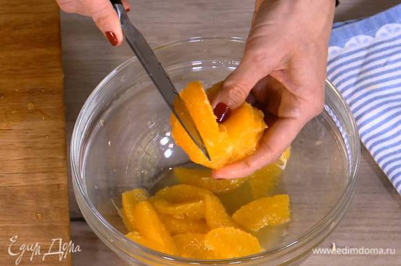 С одного апельсина ножом срезать цедру, затем почистить оба апельсина и вырезать мякоть, сохранив при этом выделившийся сок.