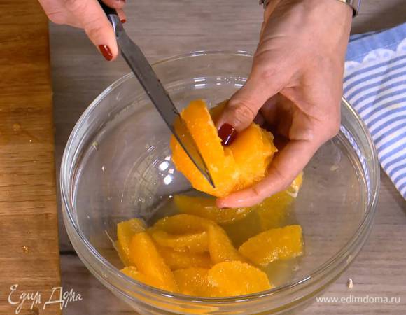 С одного апельсина ножом срезать цедру, затем почистить оба апельсина и вырезать мякоть, сохранив при этом выделившийся сок.