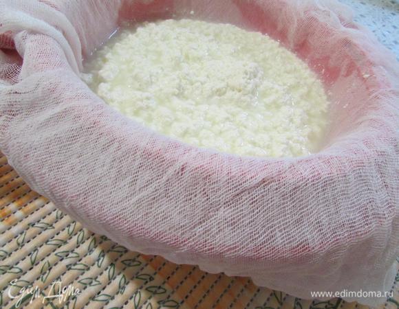 Сито или дуршлаг проложить двойным слоем марли. Откинуть молочные хлопья. Дать стечь сыворотке. Сыворотку сохранить.