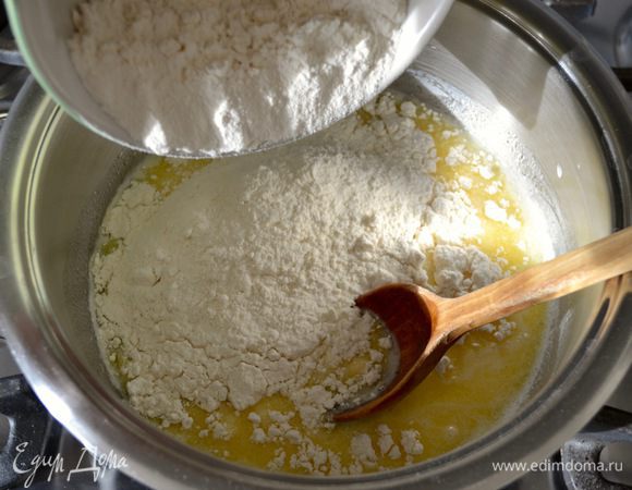 Уменьшить огонь до среднего и сразу всыпать всю муку. Энергично перемешать, чтобы не было комочков.