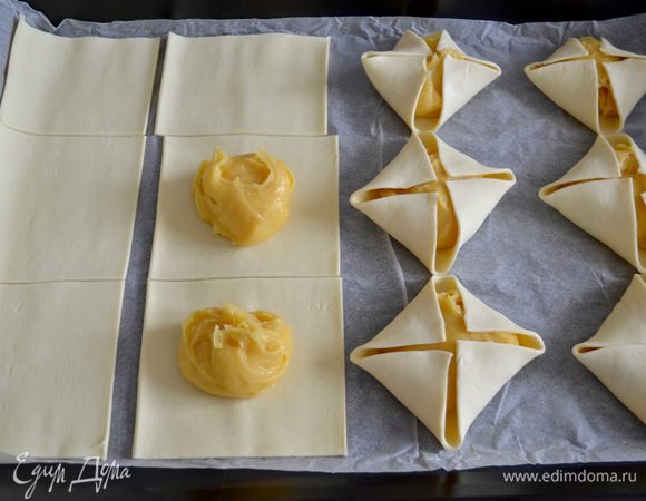На каждый квадрат слоеного теста выложить по 1 ст. л. заварного теста. Уголки квадратов завернуть на заварное тесто, но не скреплять их между собой.