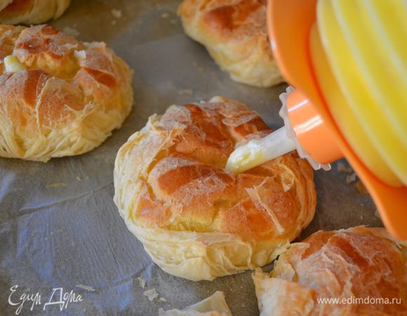 С помощью длинной насадки и кондитерского мешка заполнить каждое пирожное кремом.