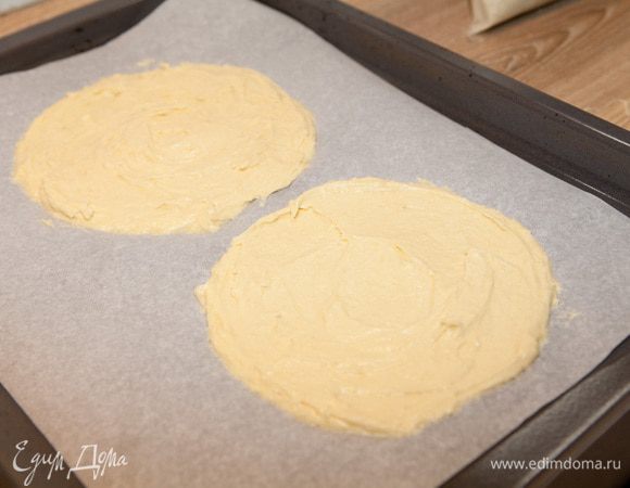 На застеленный пергаментной бумагой противень равномерно нанесите тесто тонким слоем (около 5 мм). Диаметр должен быть чуть больше диаметра формы.