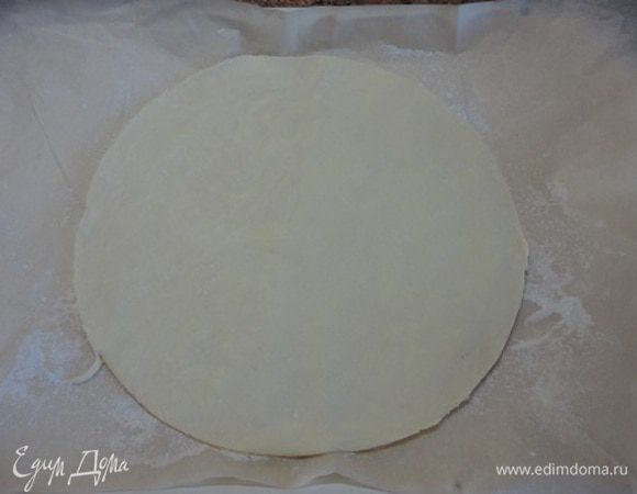 1 лист теста (или половину, если оно у вас цельным куском) раскатать так, чтобы можно было вырезать круг диаметром 25 см. Я сразу выкладываю круг на лист для выпечки, выстланный пекарской бумагой. Этот лист и оставшееся тесто пока поместите в холодильник (у меня для этого идеальная температура на лоджии -1)