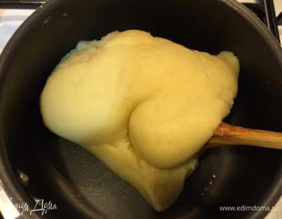 Всыпать всю муку и быстро перемешать деревянной ложкой. Хорошо перемешать, не должно быть комочков и тесто должно собраться в шар. Переложить тесто в миску для взбивания.