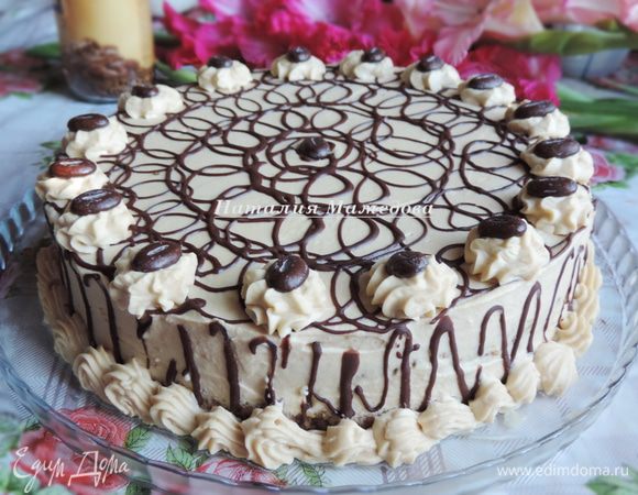 Торт обмазать оставшимся кремом, выровнять поверхность. Украсить цветочками из крема, мне крема хватило и на бордюр. Затем я растопила примерно 30 грамм черного шоколада и украсила торт шоколадными завитками и шоколадными кофейными зернами. Перед подачей торт должен пропитаться в холодильнике минимум пару часов, но чем дольше он простоит, тем вкуснее станет. У меня он стоял в холодильнике ночь.