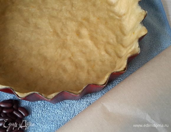 Тесто равномерно распределить по форме диаметром 24 см. Дно потыкать вилкой. Сверху как обычно пекарскую бумагу с фасолью. Выпекаем в разогретой до 220°С духовке 15 минут.