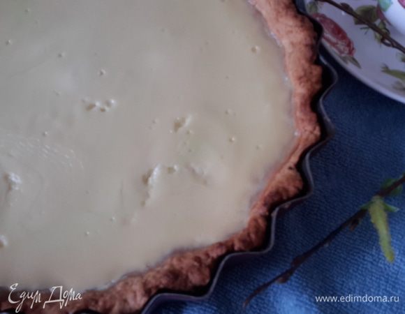 Достать корж. Убрать бумагу с фасолью. Температуру в духовке уменьшить до 160°С. Равномерно вылить крем на корж и снова поставить в духовку на 1 час. Время нужно регулировать, все зависит от духовки. Крем должен схватиться и стать красивого молочного цвета. Все неровности при остывании уйдут.