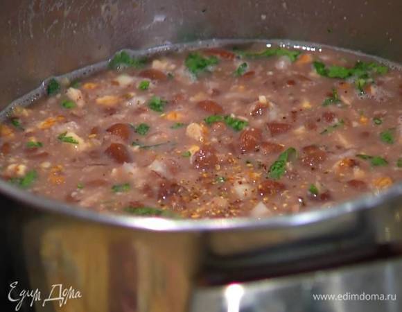 Влить к фасоли жидкость, в которой она варилась, посыпать острым перцем, хмели-сунели и прогревать все на медленном огне 6–7 минут.