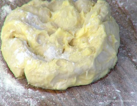 Расстелить на рабочей поверхности пищевую пленку в два слоя, выложить тесто и смазать его со всех сторон 100 г предварительно размягченного сливочного масла, стараясь слегка вбить его в тесто. Завернуть тесто в пленку и отправить на 10–15 минут в холодильник.