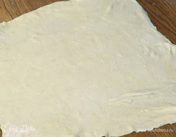Рабочую поверхность присыпать оставшейся мукой, выложить тесто и раскатать его как можно тоньше.