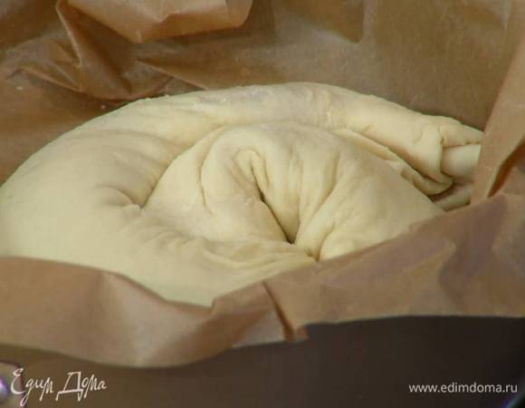 Форму для выпечки выстелить пищевой бумагой, выложить тесто и смазать сверху оставшимся сливочным маслом. Выпекать пирог в разогретой духовке 15 минут.