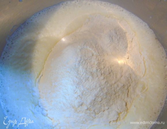 Затем так же влейте молоко, еще раз взбейте. Муку просейте и смешайте с разрыхлителем. Всыпьте к смеси. 