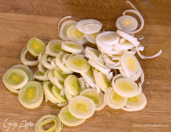 Светлую часть лука-порея нарезать кольцами.