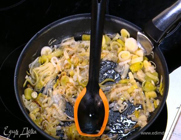 Чеснок почистить, мелко порезать и добавить в сковороду с пореем, все немного посолить и слегка обжарить.