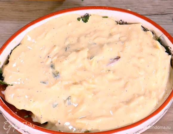 Петрушку, кинзу и базилик крупно порезать, посыпать помидоры в форме, все посолить и залить яично-сырной смесью.