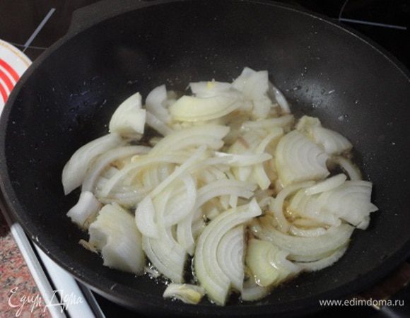 Этими грибочками выложить стеночки формы. Луковицу нарезать полукольцами и потушить.