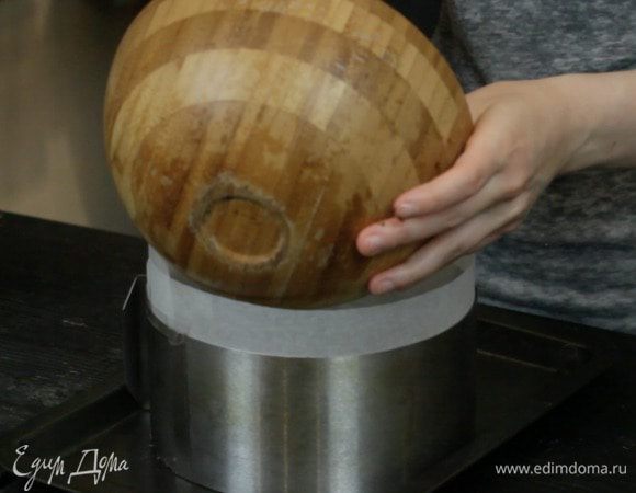 Обернуть форму пекарской бумагой и выложить на дно слой печенья. Убрать пока в холодильник.