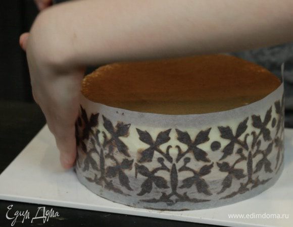 Затем, когда шоколад уже наполовину застыл, аккуратно оборачиваем торт, немного прижимая к бокам. Но не сильно нажимаем, чтобы не деформировать узор. Убираем в холодильник до застывания шоколада. 