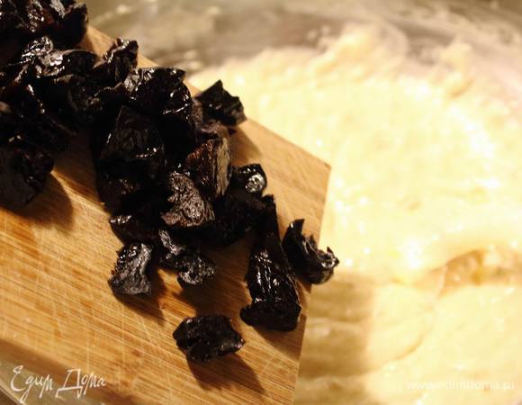 Чернослив нарезать на четвертинки и вмешать в тесто.