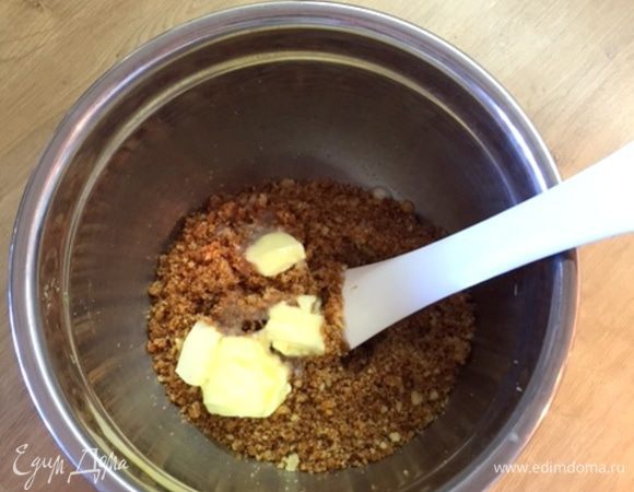 Растапливаем сливочное масло и перемешиваем с бисквитной крошкой (можно взять печенье).