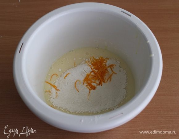 Просеять муку с разрыхлителем, добавить цедру одного апельсина, перемешать