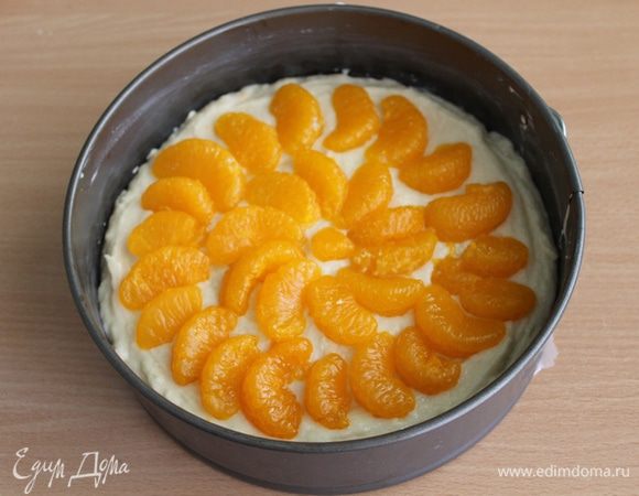 Сверху выложить консервированные мандарины, слегка их вдавив.