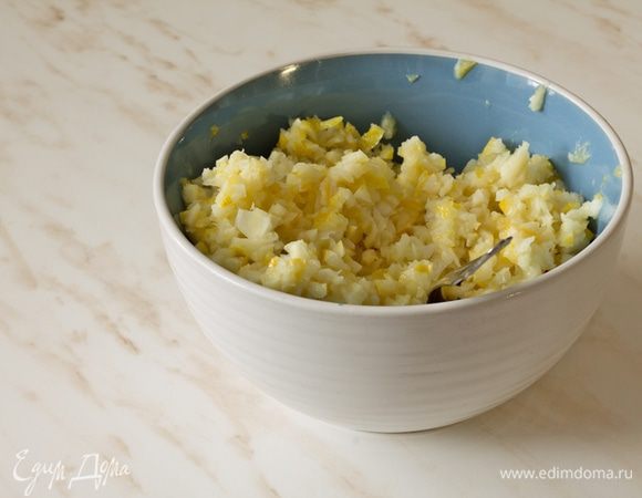 Лимоны нарезать кружочками, удалить косточки. Отложить 12 равных кружков, остальные измельчить, не превращая в пюре. Смешать с 200 г сахара.